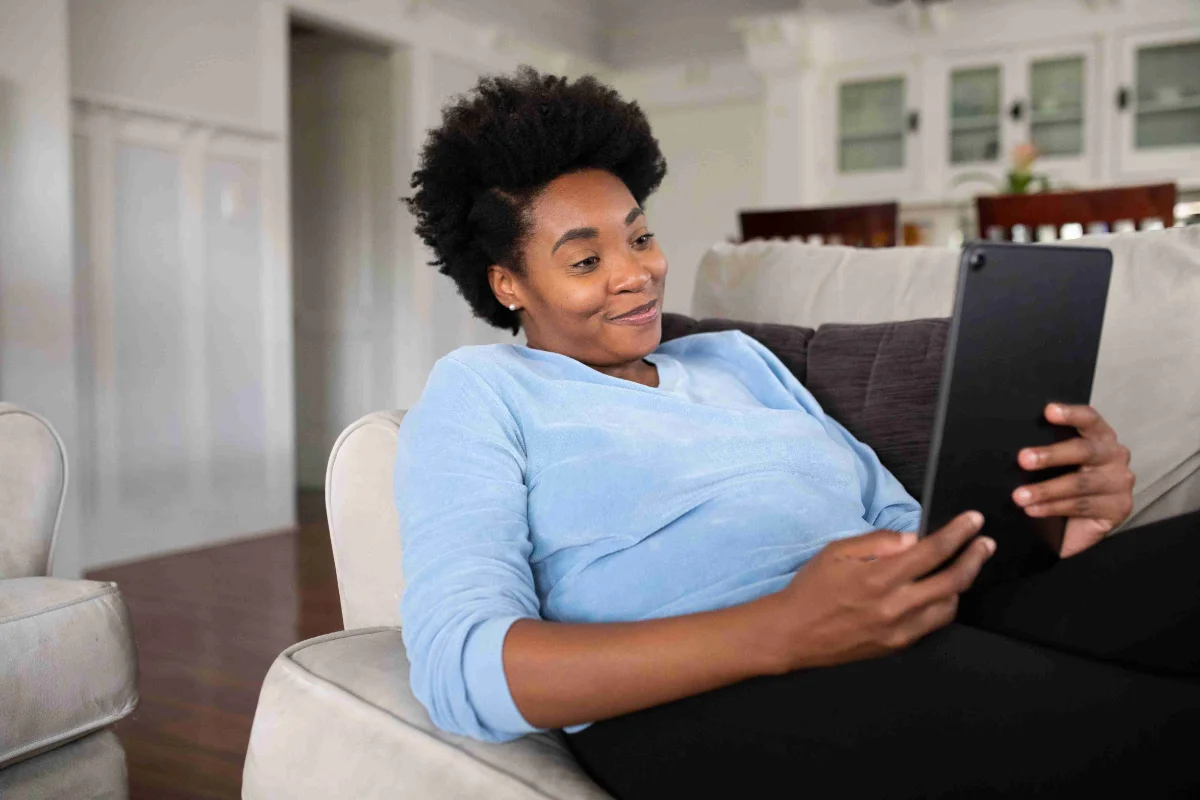 Woman relaxing on a sofa at home using Vyne